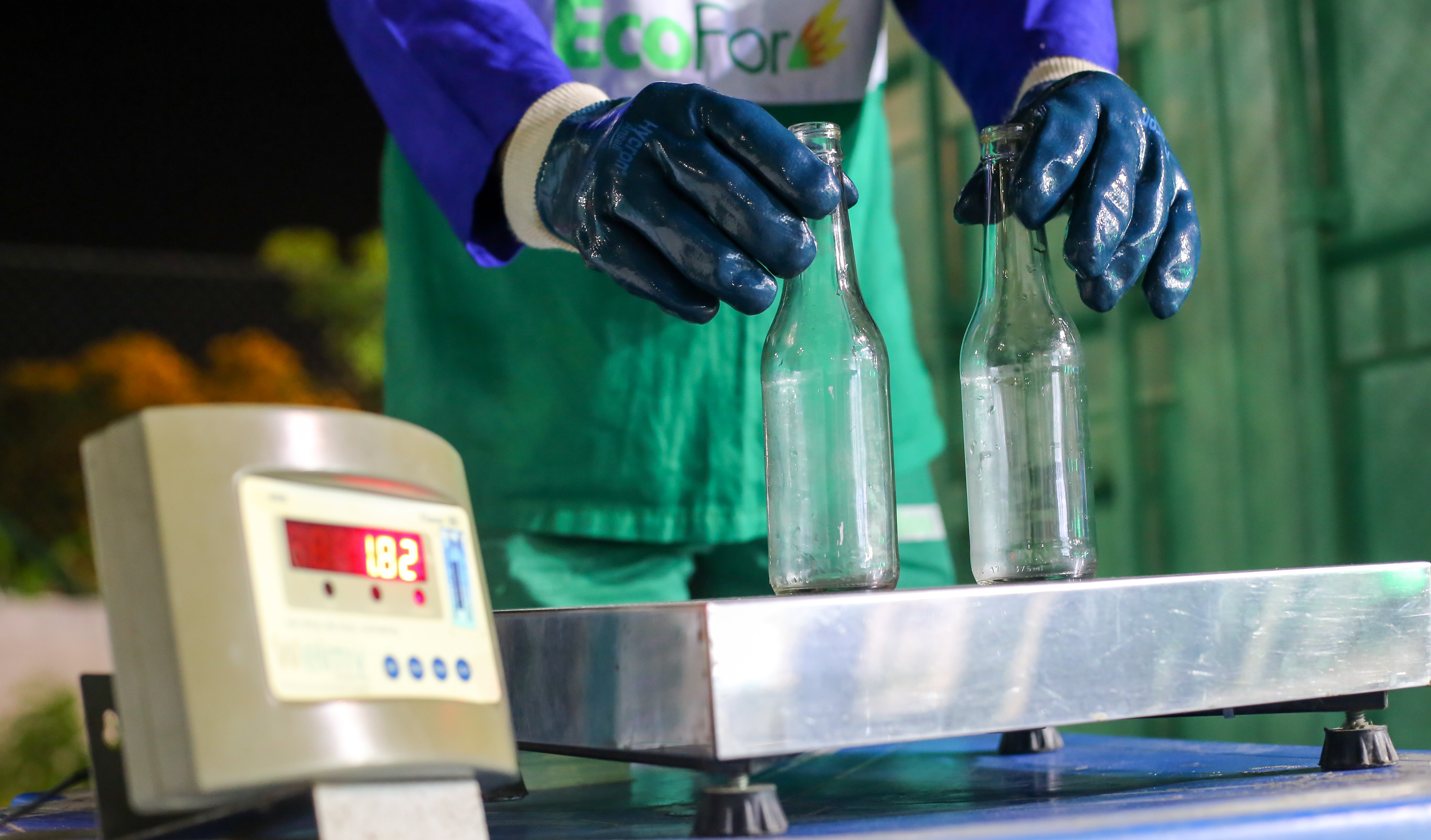 balança com duas garrafas de vidro sendo pesadas